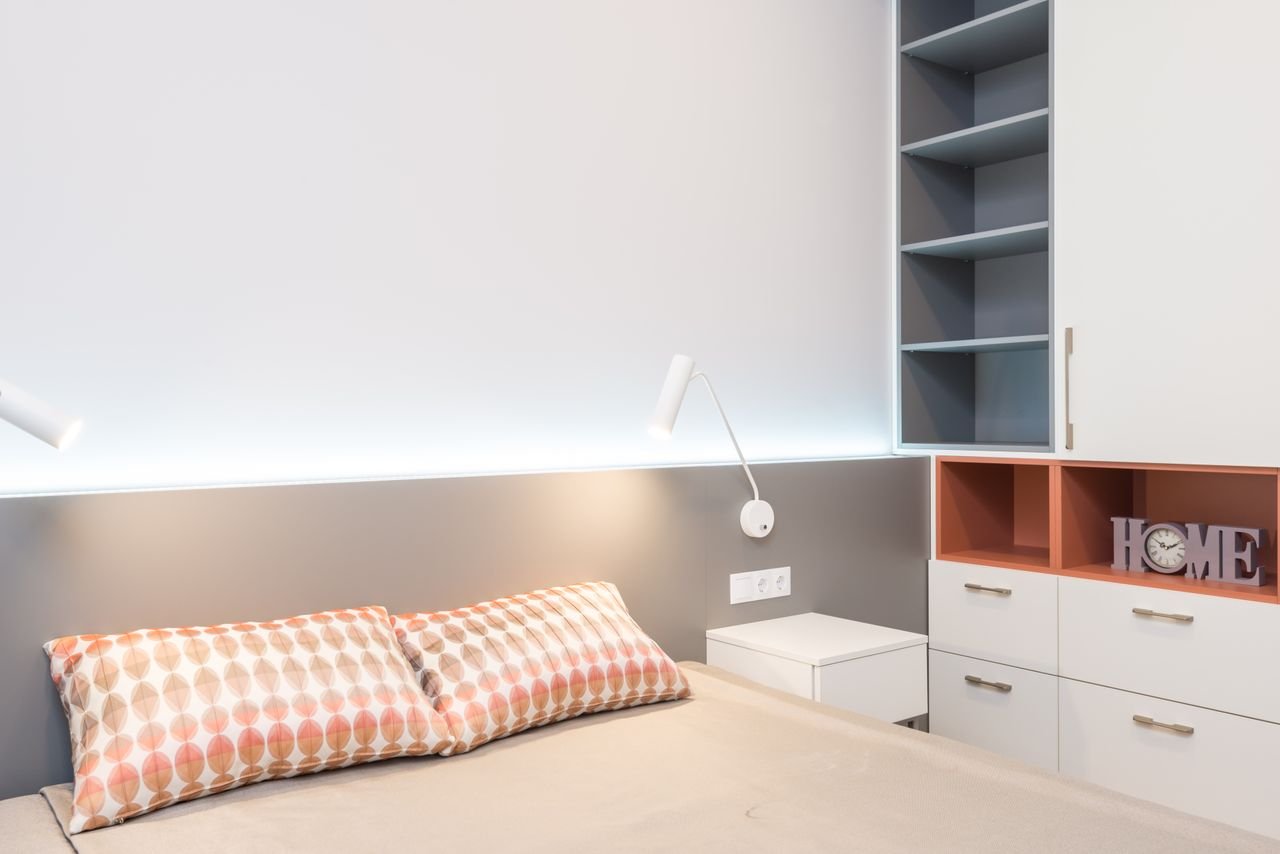 Habitación pequeña decorada con estanterías de pared y colores neutros